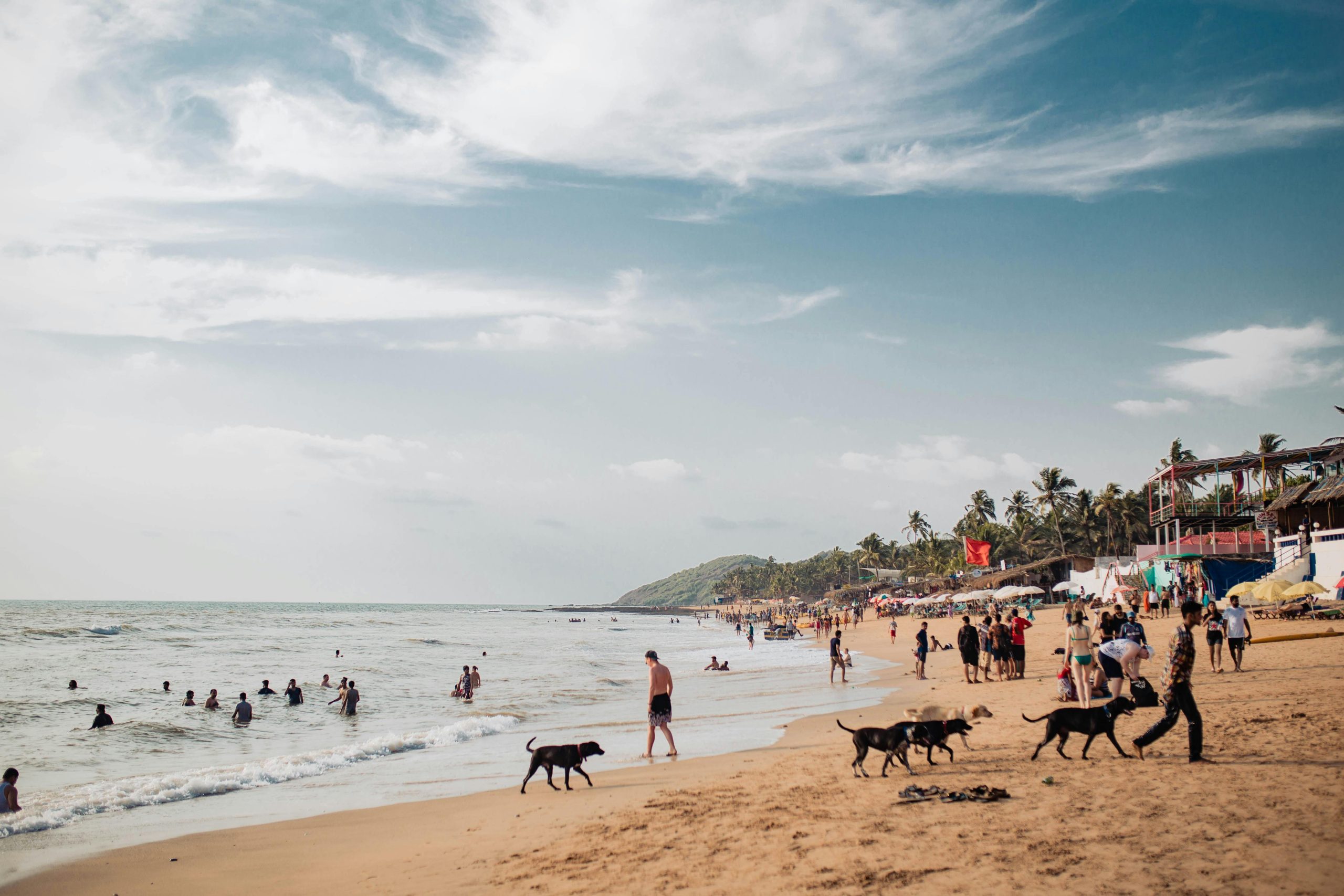 Bustling Baga Beach in Goa, India, with people enjoying a sunny day by the sea.